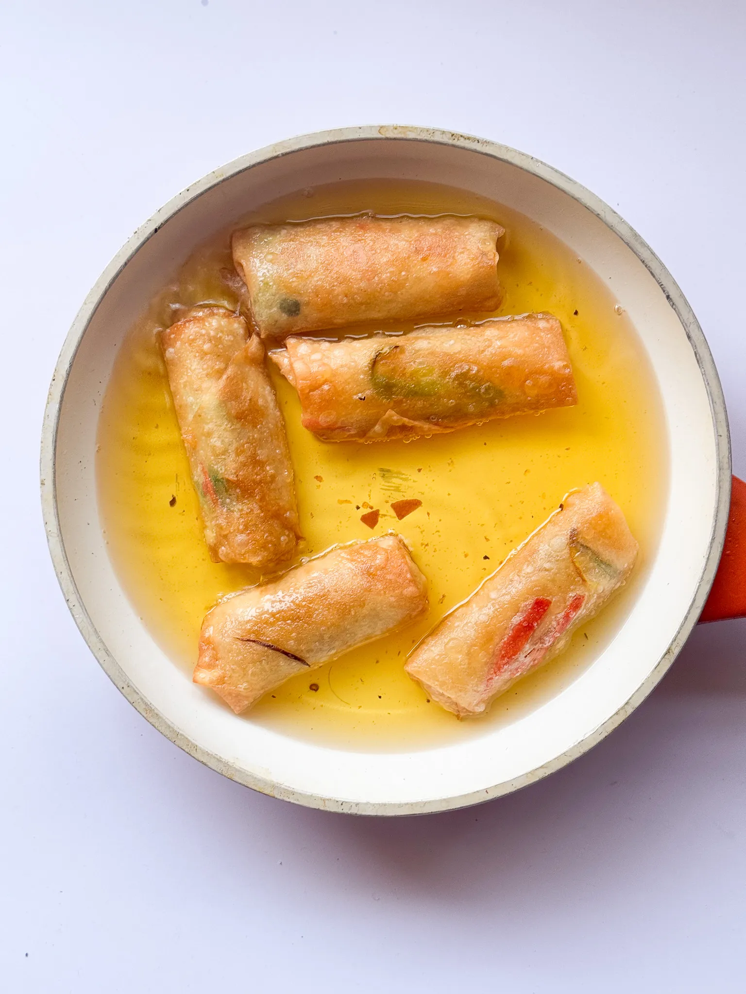 Deep frying the spring rolls.