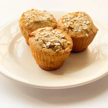 Banana oat flour muffins with rolled oats topping.