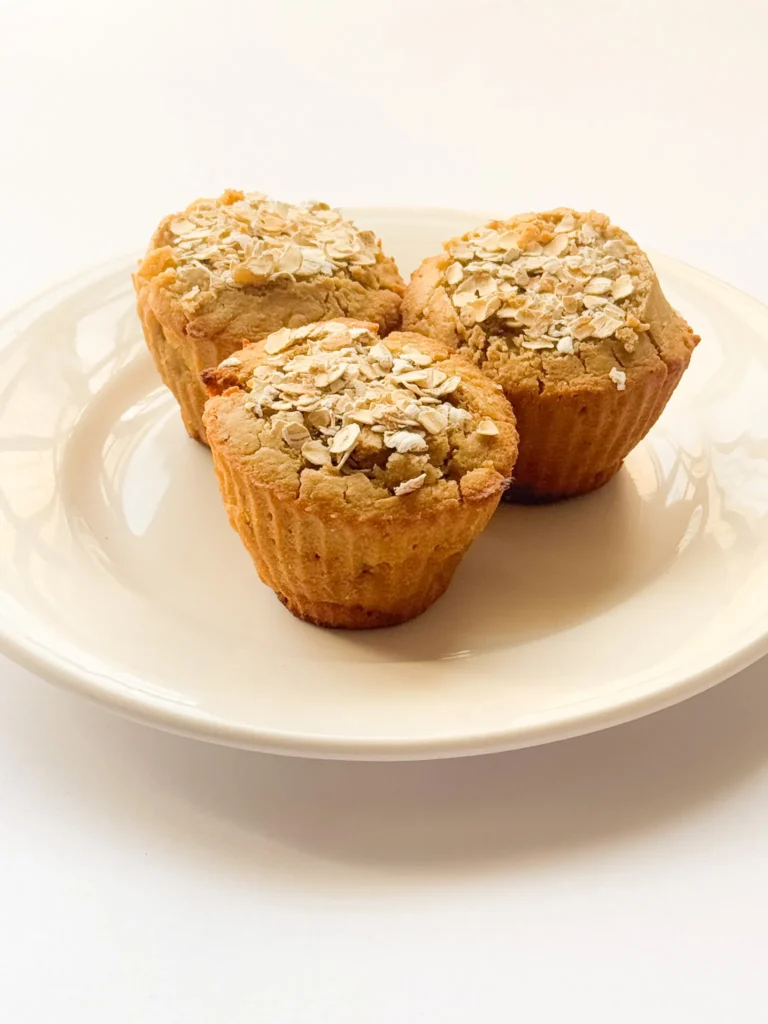 Banana oat flour muffins with rolled oats topping.