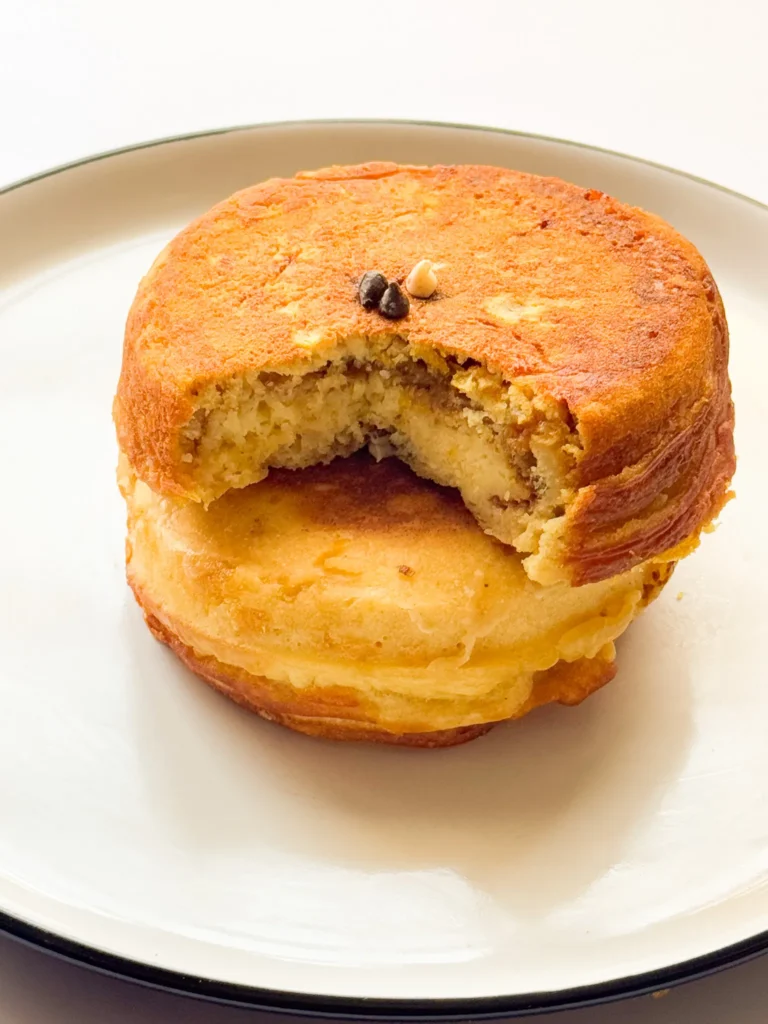 Fluffy Japanese Souffle Pancakes stacked in a plate: The sliced, top pancake sitting on top of complete, bottom pancake.