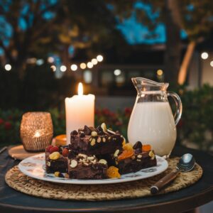 Fudgy brownies made with bananas, nut butter of your choice, and cocoa powder, with a jug of milk against a romantic backdrop.