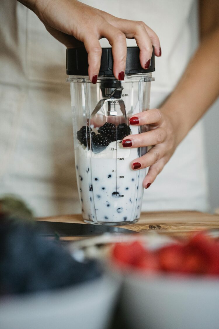 adding fruit to blender with yogurt